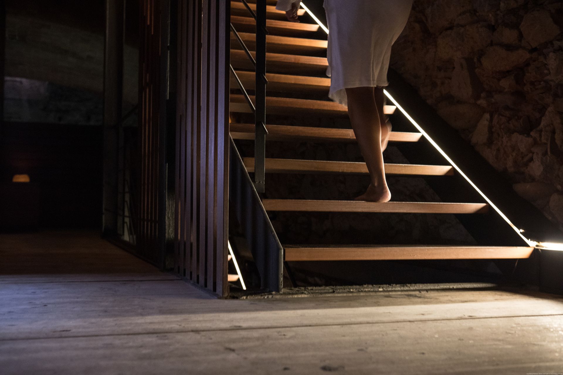 Dona amb tovallola pujant per les escales d'un bany termal.